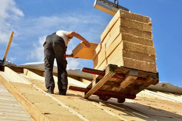 Dachdecker mit Dämmstoff auf dem Dach