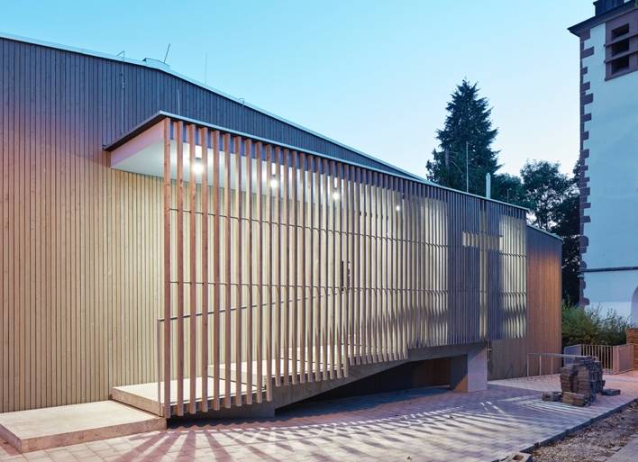 Foto des renovierten Gemeindehauses der Kirchengemeinde Pforzheim Huchenfeld. Blick auf den in hölzernen Leisten gestalteten Eingangsbereich