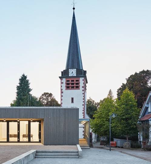 Foto des renovierten Gemeindehauses der Kirchengemeinde Pforzheim Huchenfeld. Blick auf die Terrasse beleuchtet bei Nacht