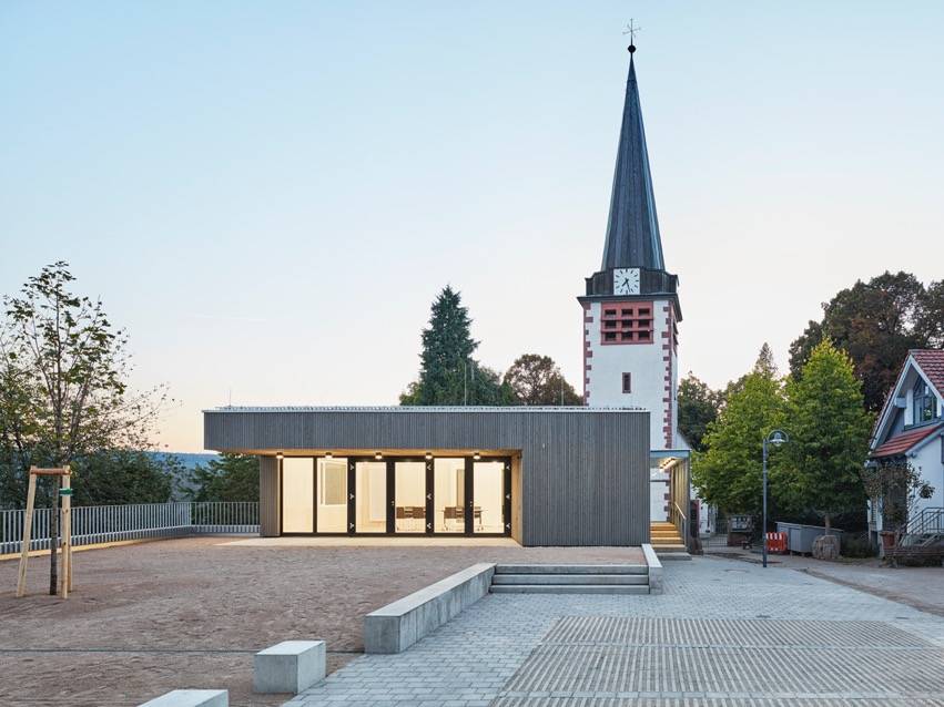 Foto des renovierten Gemeindehauses der Kirchengemeinde Pforzheim Huchenfeld. Blick auf die Terrasse beleuchtet bei Nacht