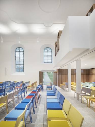 Foto des hellen Innenraums mit blauen und gelben Stuhlreihen