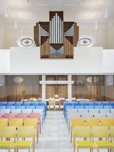 Foto der Orgel der Kirche Reichartshausen über den bunten Stuhlreihen