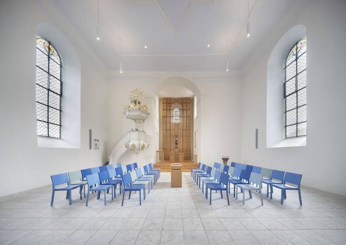 Foto einer Stuhlformation mit gegenüberliegenden Stühlen um das Taufbecken der Kirche