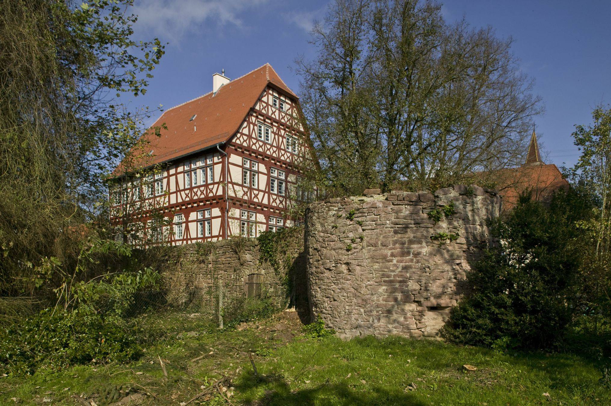 Foto des renovierten Wasserschlosses von Außen.  Blick von unten auf die steinerne Schlossmauer