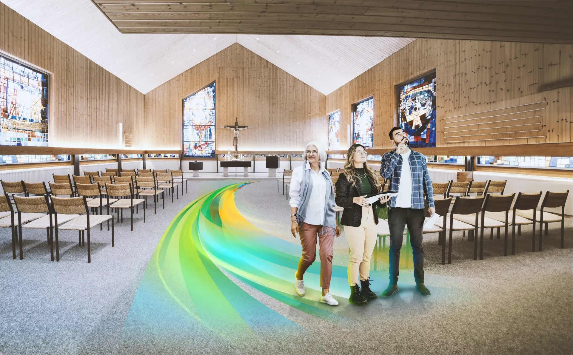 Der Innenraum der Auferstehungskirche Litzelstetten. Drei Personen gehen auf einem farbigen Weg Richtung Ausgang.