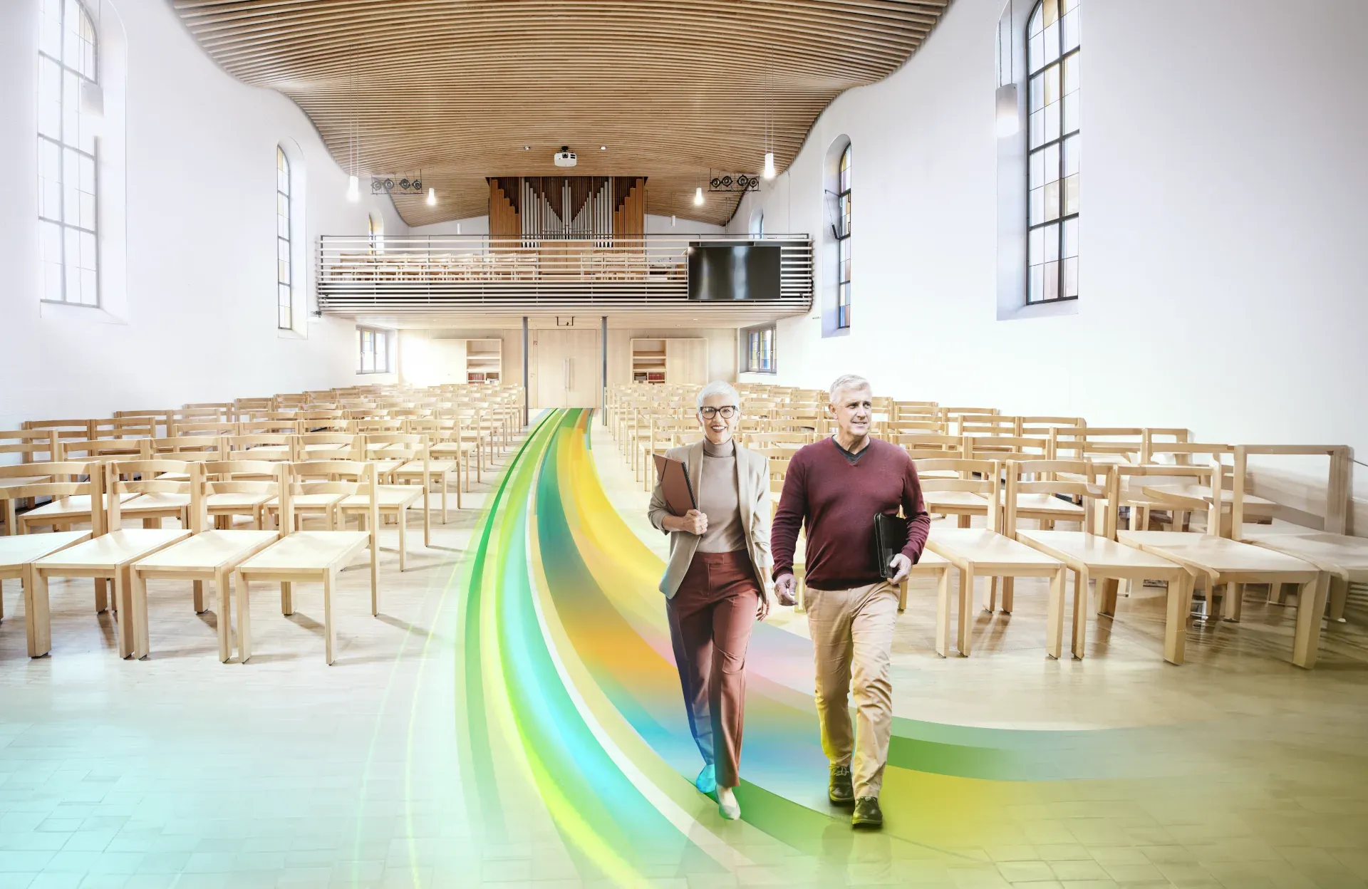 Quelle: Foto Nina Baisch, Nina Baisch Der Innenraum der Christuskirche Wollmatingen. Ein Mann und eine Frau gehen auf einem farbigen Weg durch den Mittelgang nach vorn.
