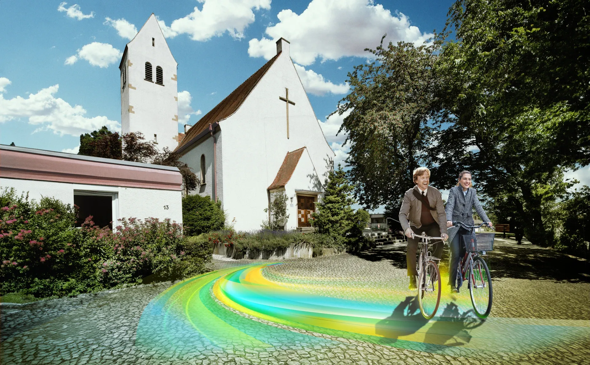 Der Vorplatz der Christuskirche Wollmatingen. Ein Mann und eine Frau auf Fahrrädern fahren auf einem farbigen Weg vom Kircheneingang weg.  