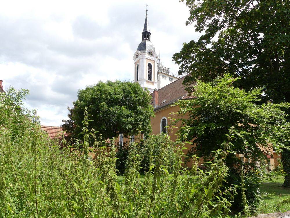 Umriss Kirche, davor ein Garten